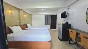 a hotel room with two beds and a television at Ratchawong Place ราชวงศ์ เพลส --หลังพ่อขุน-- in Phayao