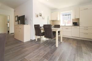 a kitchen with a table and chairs in a room at Flott-am-Meer in Norddeich