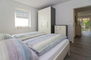 a bedroom with a bed and a dresser and a window at Flott-am-Meer in Norddeich