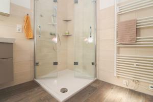 a shower with a glass door in a bathroom at Flott-am-Meer in Norddeich +7 photos