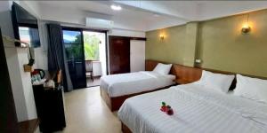 two beds in a hotel room with two beds at Ratchawong Place ราชวงศ์ เพลส --หลังพ่อขุน-- in Phayao