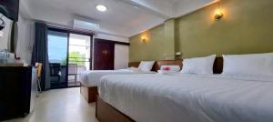 a hotel room with two beds and a balcony at Ratchawong Place ราชวงศ์ เพลส --หลังพ่อขุน-- in Phayao +11 photos