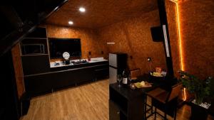 a room with a kitchen with a refrigerator and a table at Chalé Queen in Brasília