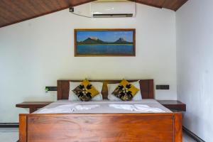 a bedroom with a wooden bed with yellow pillows at Lion See Hotel - Sigiriya in Sigiriya +50 photos