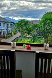 a balcony with a view of a street and palm trees at Ratchawong Place ราชวงศ์ เพลส --หลังพ่อขุน-- in Phayao
