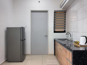 a kitchen with a refrigerator and a counter top at Atlas Serviced Suites in Butterworth +8 photos