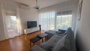 a living room with a couch and a tv at App Jadranka Matak in Rabac