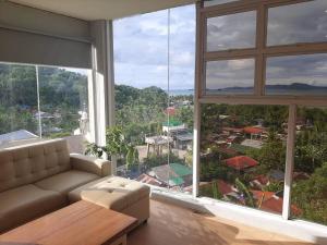 a living room with a couch and a large window at Mamima BnB in Caramoan