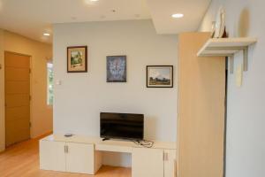 a living room with a tv on a white wall at Mamima BnB in Caramoan