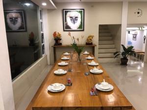 a long wooden table in a room with plates and dishes at Mamima BnB in Caramoan +69 photos