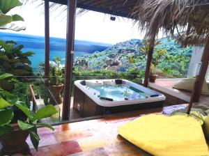 a hot tub on a patio with a view of the ocean at Villa Jacuzzi Seaview Villa in Chaweng Noi Beach