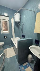 a blue tiled bathroom with a toilet and a sink at App Jadranka Matak in Rabac +35 photos