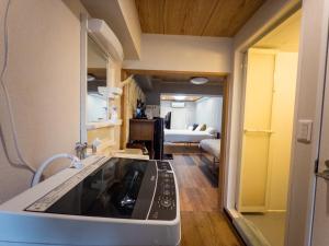 a kitchen with a sink and a living room at KANDA HOUSE!! Shin-Okubo Walkable Modern Stay with Shinjuku Access in Tokyo