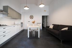 a kitchen and living room with a table and a couch at Dimora Altea in Taranto