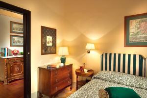 um quarto com uma cama, uma cómoda e uma cadeira em Residenza Johanna I em Florença