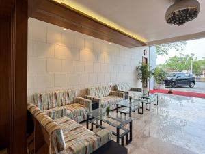 a lobby with couches and tables in a building at Hotel Ashoka Inn in Wardha