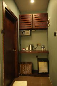 a small kitchen with a sink and a shelf at Hotel Sangiliyan in Jaffna
