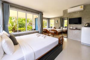 a bedroom with a large bed and a living room at Nitiporn Resort kohphayam & seaagain bar and restaurants in Ko Phayam