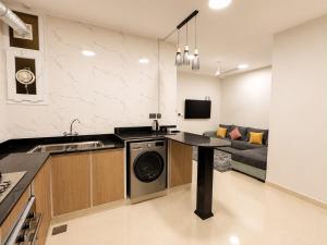 a kitchen with a washer and dryer in a room at ملاذ للشقق المخدومة in Salalah