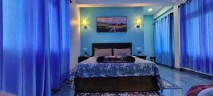 a blue bedroom with a bed with blue curtains at Lavender Guesthouse in Cherrapunji