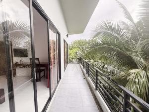 an indoor balcony with glass doors and palm trees at Baan Phu Place in Ban Suan