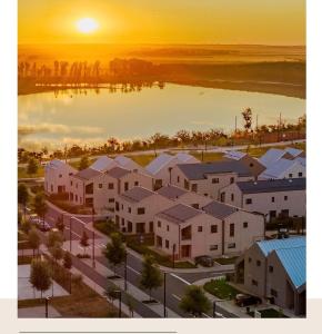 an aerial view of a city with houses and a lake at Lake side story in Frumuşani