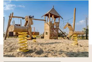 a playground with a wooden horse and a swing at Lake side story in Frumuşani