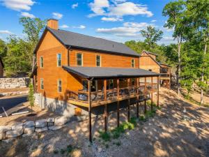 a large wooden house with a black roof at Lumberjack Lodge with Amenities in Hollister