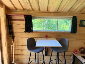 a table and two chairs in a room with a window at The Hideout Log Cabin- 2km to Klarälvsbanan and swimming area in Munkfors +24 photos