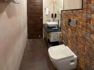 a bathroom with a toilet and a sink at Hotel Ashoka Inn in Wardha +35 photos