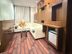 a living room with a white couch and a table at Hotel Ashoka Inn in Wardha