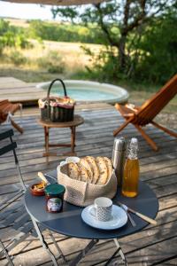 a picnic table with food and drinks on a deck at Roulotte de Combeplane in Carnac-Rouffiac +9 photos