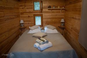 a bedroom with two beds in a log cabin at Roulotte de Combeplane in Carnac-Rouffiac
