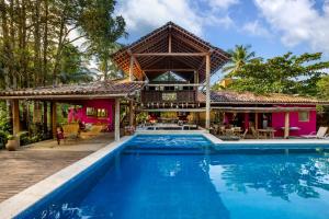 a house with a swimming pool in front of a house at Pousada Hibisco in Trancoso