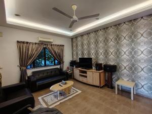 a living room with a couch and a tv at MELAKA BEACH VILLA ( B TYPE ) in Malacca