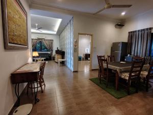 a dining room with a table and chairs and a living room at MELAKA BEACH VILLA ( B TYPE ) in Malacca