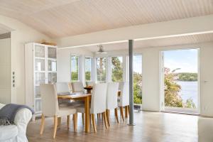 a dining room with white chairs and a table with a view at Spectacular lake plot, Stockholm archipelago in Dalarö