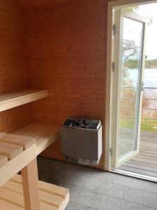 a room with a stove in a wooden cabin at Spectacular lake plot, Stockholm archipelago in Dalarö