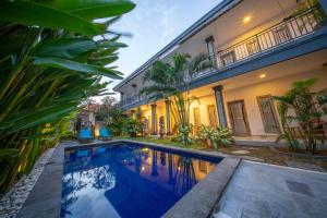 an exterior view of a house with a swimming pool at Eva Guest House in Canggu