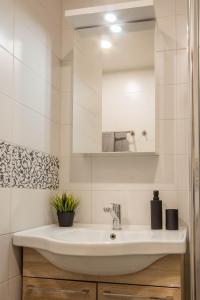 a white bathroom with a sink and a mirror at Aardla Cozy Apartment in Tartu +13 photos