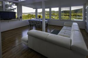 a living room with a white couch and a table at Riverside Forest Prestige in Chlʼaba