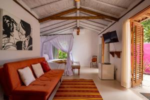 a living room with a couch and a tv at Pousada Hibisco in Trancoso