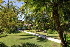 a person walking down a path in a park at Pousada Hibisco in Trancoso