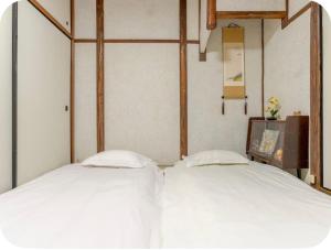two beds sitting next to each other in a bedroom at 2 floors japanese style, direct to KIX, 10mins train to Namba, 5mins walk to stn , 2-6ppl in Osaka