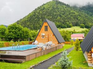 a home with a pool and a house at Eco cottage in Borjomi with pool 2 in Sadgeri