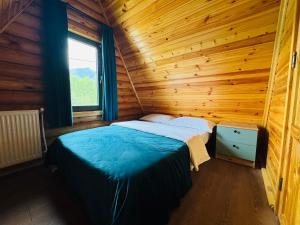 a bedroom with a bed in a wooden cabin at Eco cottage in Borjomi with pool 2 in Sadgeri