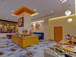 a restaurant with a buffet line with food on display at The Fern Residency, Jamnagar, Series by Marriott in Jamnagar +18 photos