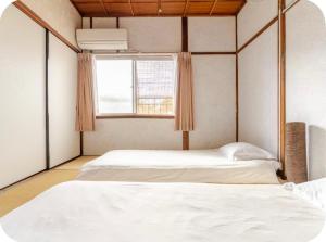 two beds in a room with a window at 2 floors japanese style, direct to KIX, 10mins train to Namba, 5mins walk to stn , 2-6ppl in Osaka