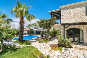 a house with a swimming pool and palm trees at Goudis Luxury Villas Lefkada Sea View & Private Pools in Tsoukalades