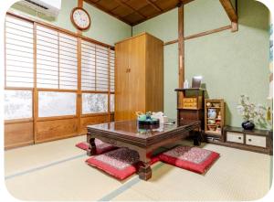 a living room with a table and a clock on the wall at 2 floors japanese style, direct to KIX, 10mins train to Namba, 5mins walk to stn , 2-6ppl in Osaka +72 photos